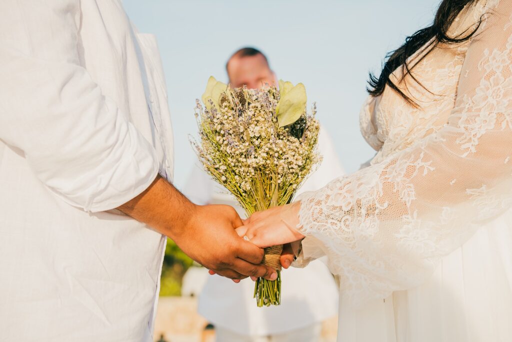 Bride and groom holding hands with bouquet at Aruba elopement