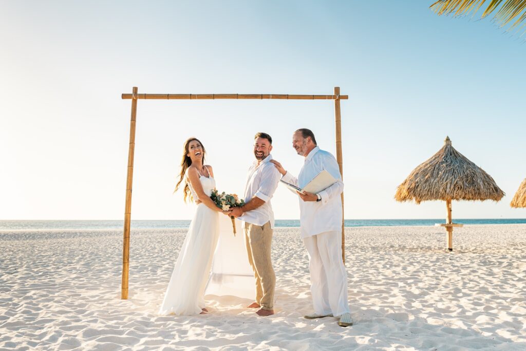 Aruba officiant laughing with groom during elopement at alter