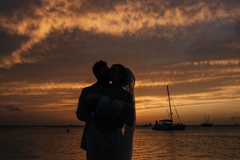 Bride and groom kissing at Aruba sunset