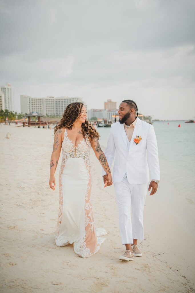 Bride and groom walking Aruba beach during elopement