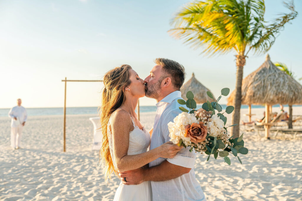 Bride and groom kissing on Aruba beach after elopement