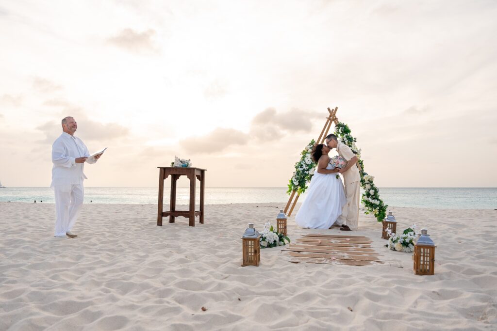 Bride and groom kissing on beach after Aruba elopement ceremony