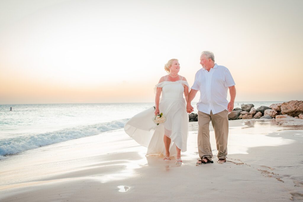 Couple walking beach after Aruba elopement
