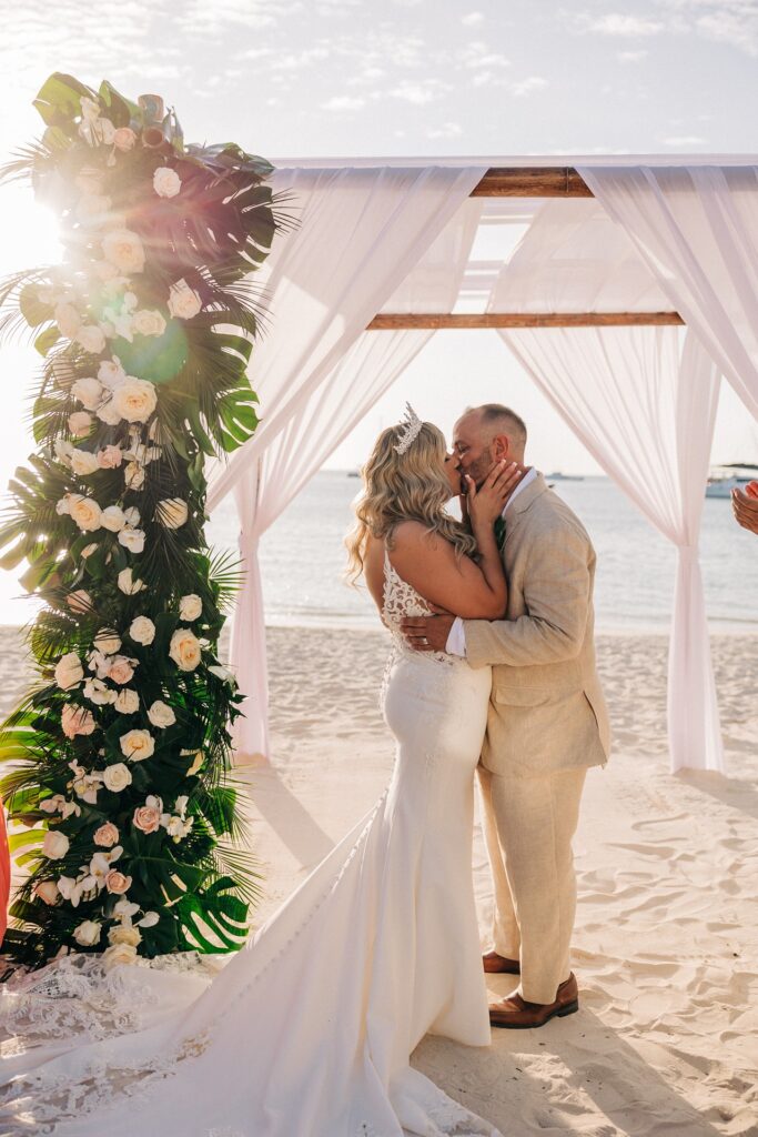 Aruba elopement couple kissing under ceremony alter