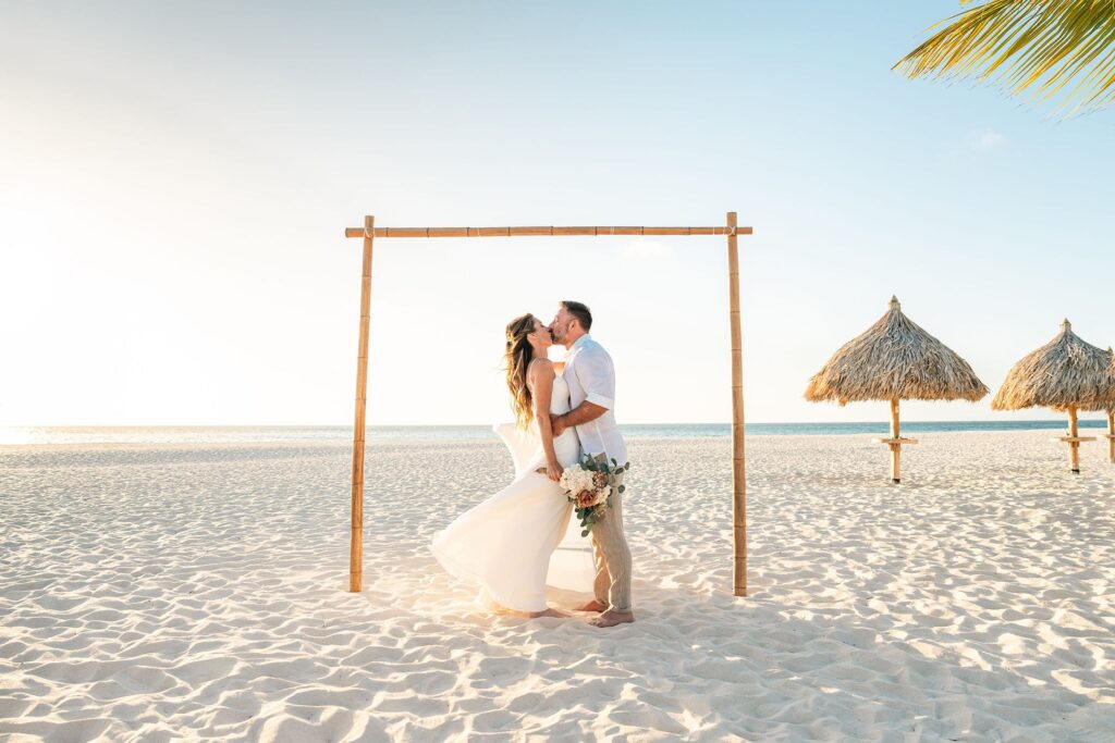 Bride and groom kissing on Aruba beach after ceremony