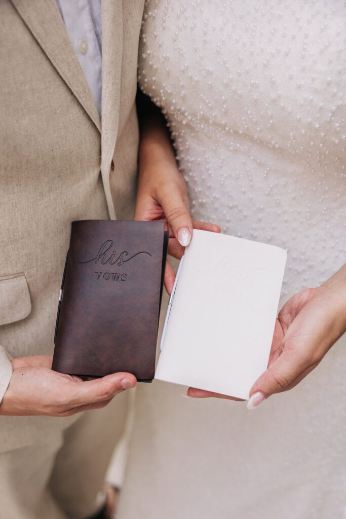Bride and groom holding leather vow books for Aruba elopement